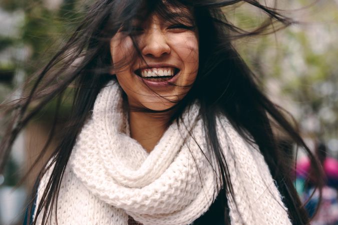 Smiling young Asian woman with wind blowing through hair