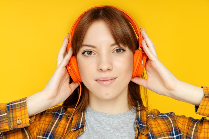 Concept of people, woman with headphones on yellow background