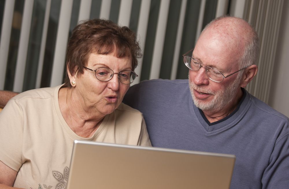 Smiling Mature Adult Couple Having Fun on the Computer