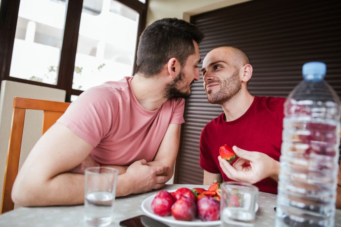 Gay couple eating strawberries