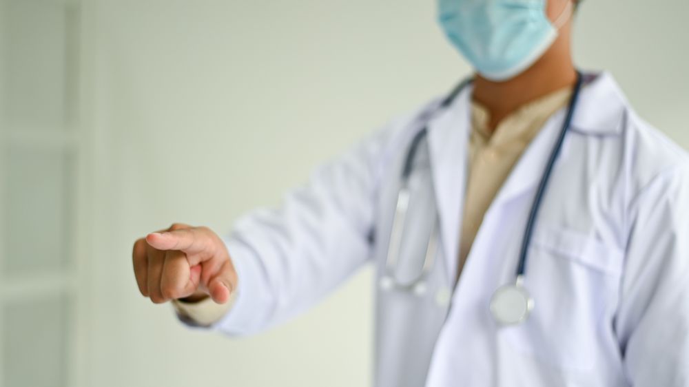 Cropped shot of A doctor in a lab uniform pointing to the front