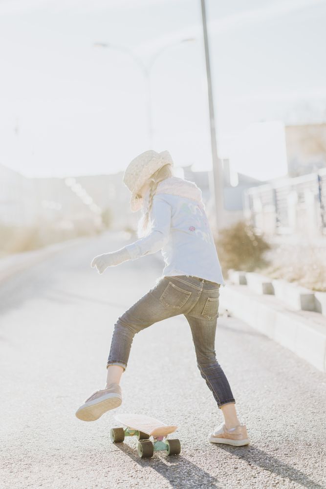 Stylish girl with skateboard on street