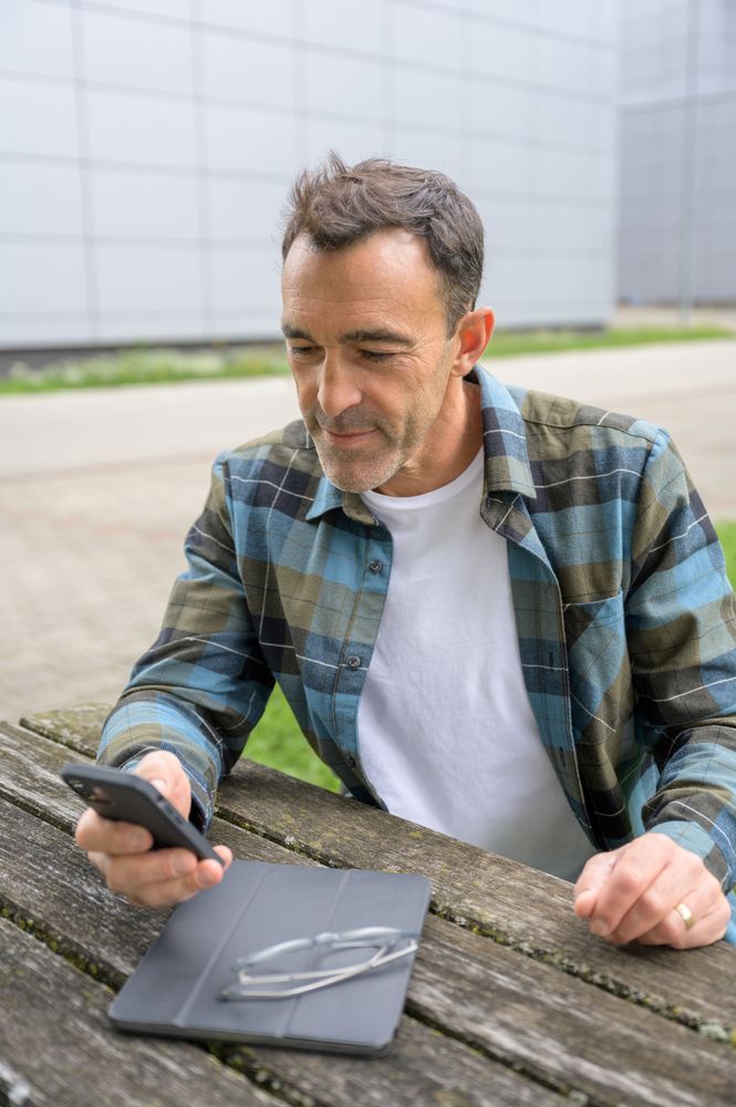 Cheerful man with smartphone and notebook