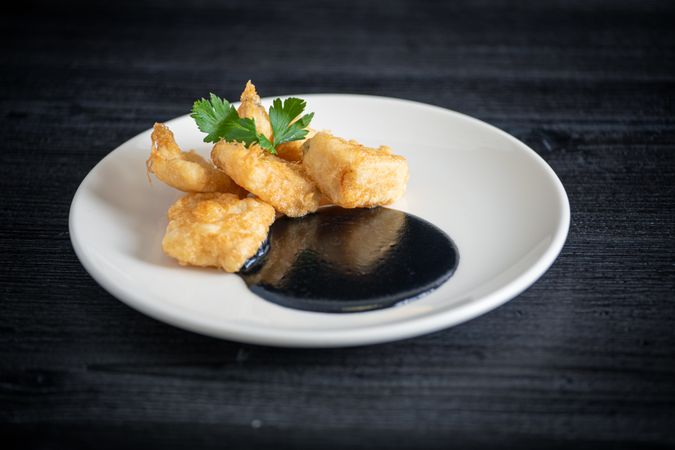 Hake breaded with squid cream in plate