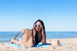 Relaxing at the Beach A Fashionable Young Woman Delightfully Enjoying the Warm Sun