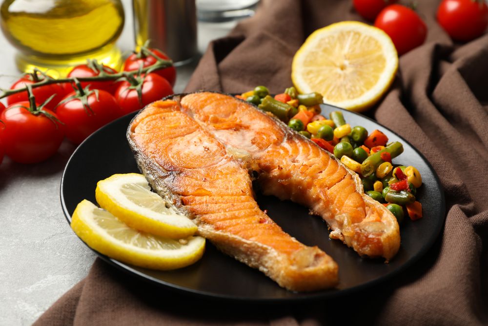 Composition with tasty grilled salmon on gray background, close up