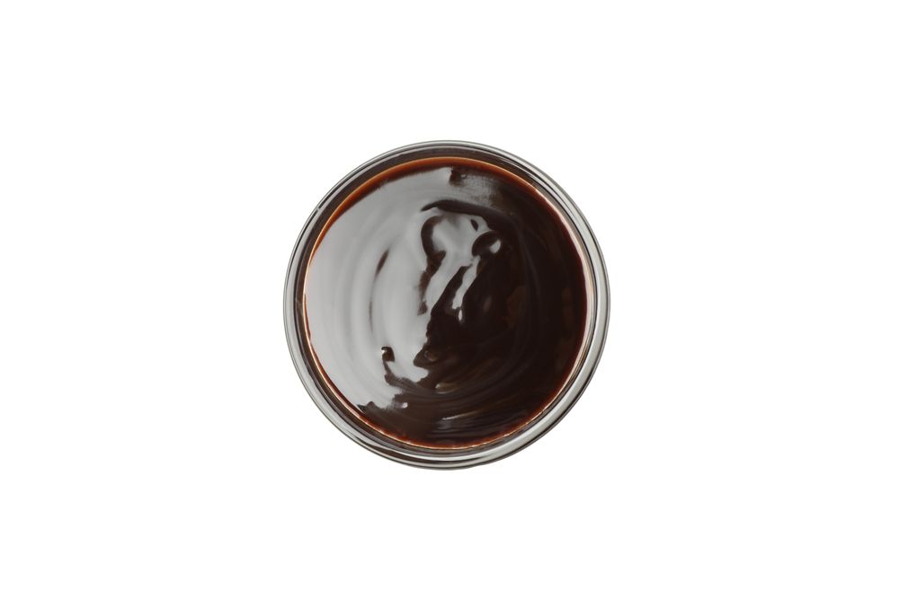 Bowl with melted chocolate isolated on neutral background