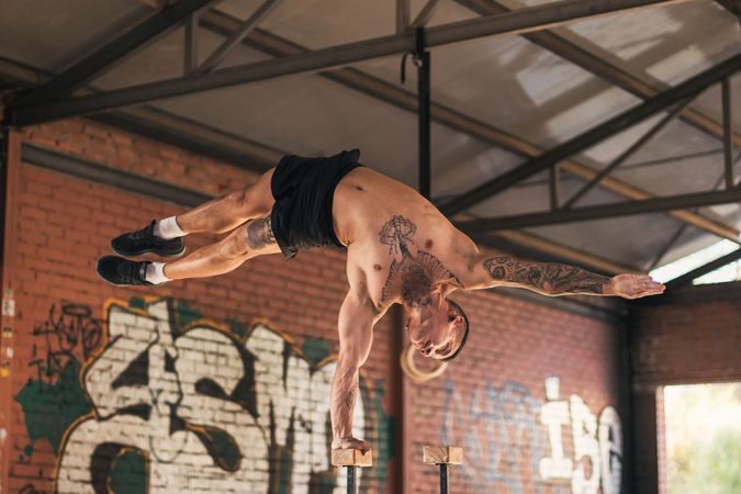 male athlete doing one hand handstand