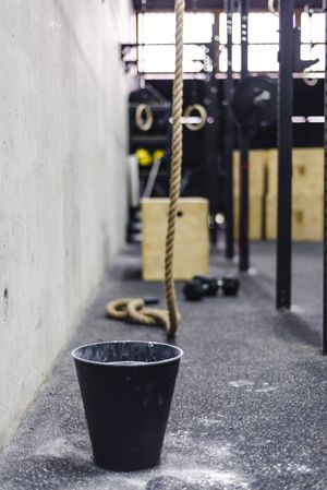 Rope near bucket of chalk in gym
