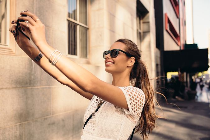 Beautiful woman wearing sunglasses and taking a selfie