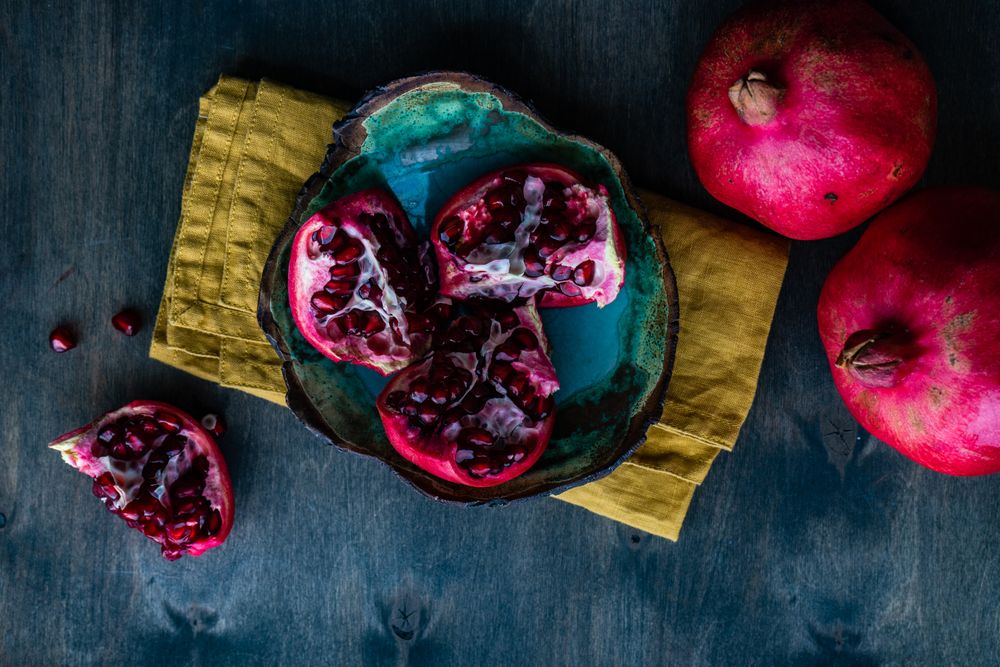 Fresh cut pomegranate in teal bowl
