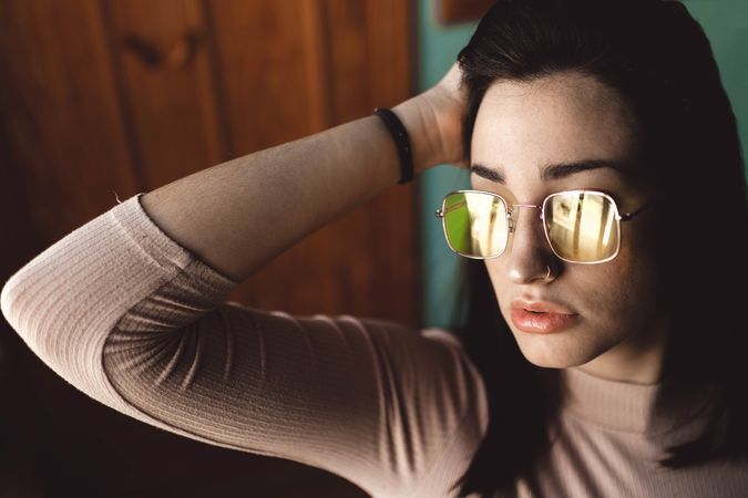 young woman portrait with yellow glasses posing