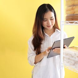 Asian Young Woman Checking Kue Kering Lebaran Stock using Tablet