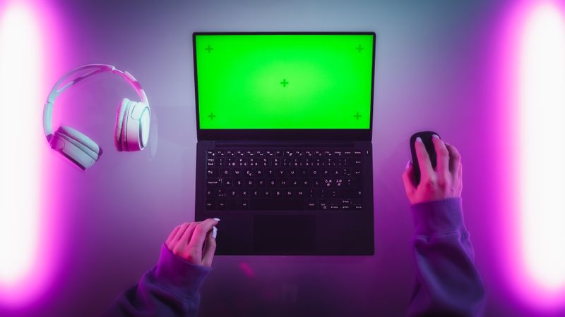 Top Down Shot of a Female Software Developer Working on a Laptop in a Stylish Room with Neon Lights. Computer with Green Screen Chroma Key Template for Digital Marketing Services, Apps, Software