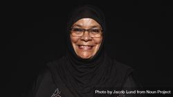 Close up of a smiling muslim woman in hijab isolated on dark background 5aOzdb