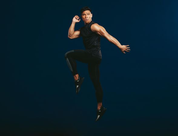 Full length of healthy male in sportswear exercising and jumping