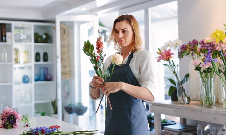 Young woman making a bouquet with fresh flowers