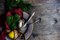 Plate with Christmas ornaments on wooden table