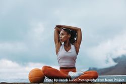 Athlete woman stretching arms outdoors on building terrace 4jlGv0