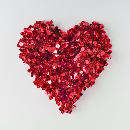 Red confetti shaped in heart on light background