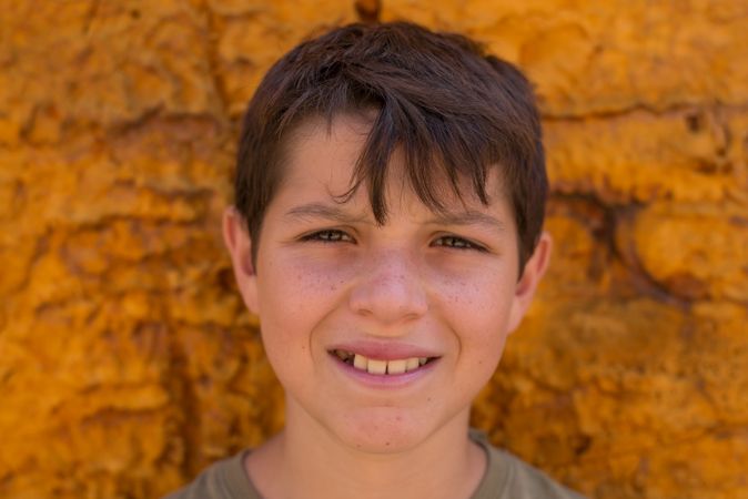 Content boy looking at camera with yellow background