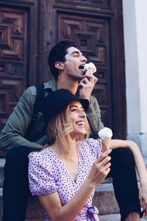 Happy couple feeding each other by ice cream