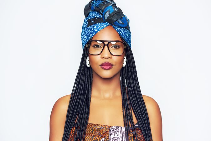 Studio portrait of woman with a confident expression wearing a blue wrap on her head