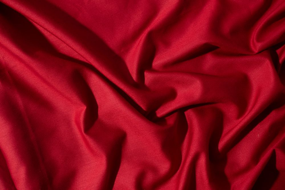 Crumpled wavy Red silky fabric background texture.