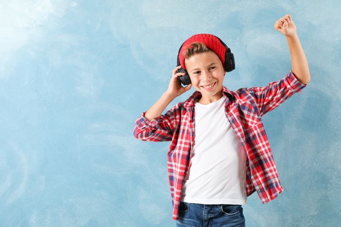 Fashion boy in headphones on color background, space for text