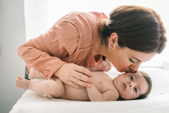 Mother kissing tenderly cute baby