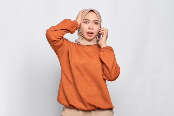 Muslim woman receiving surprising news on cell phone