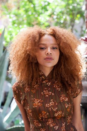 Close up portrait of a young woman with an afro facing the camera