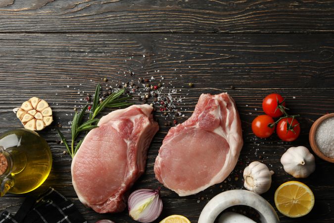 Composition with raw meat for steak and ingredients on wooden background
