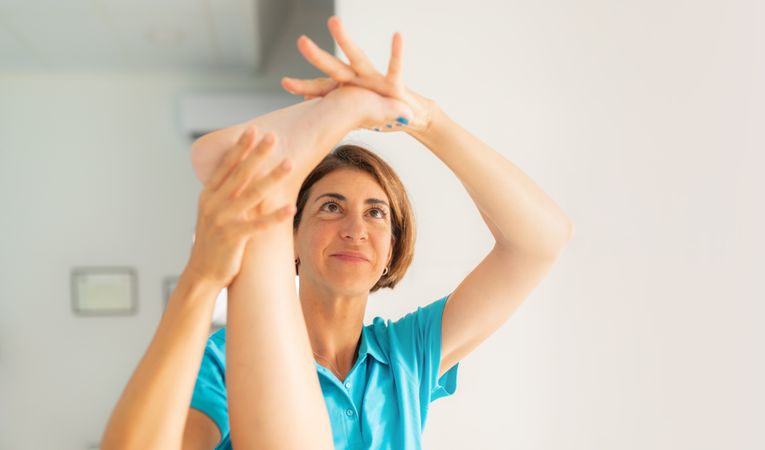 A physical therapist performs stretching exercises on her patient's foot and ankle during a massage session at the clinic