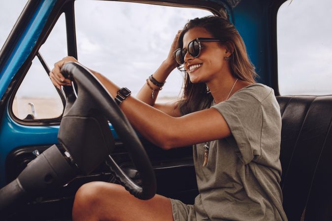 Portrait of happy young woman driving a truck