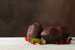 Composition with chocolate muffins and berries on wooden table