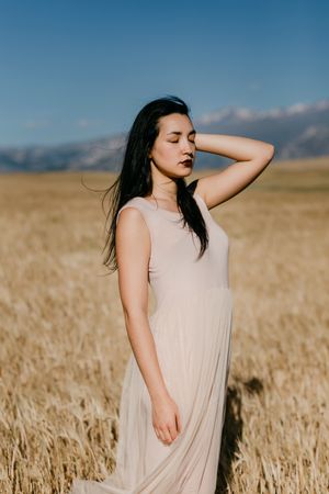 Portrait of woman in dress standing in field