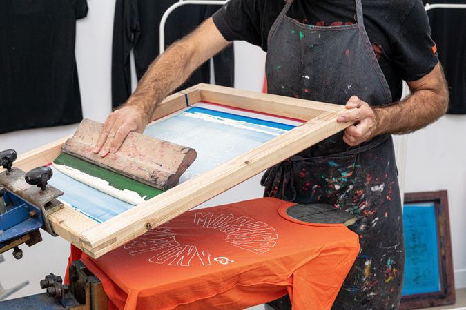 Male artist creating print on t-shirt