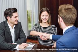 Man and woman shaking hands over a table in an office 5zozj4