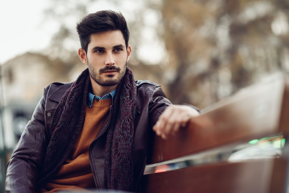 Man lost in thought sitting on bench outside