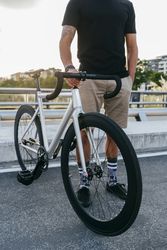 Man with bike standing on bridge