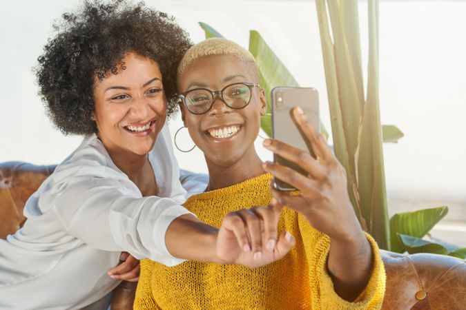 Smiling multiracial women taking selfie on smartphone