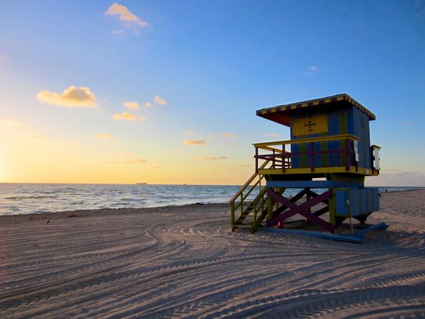 Colorful wooden cottage on sandy seashore