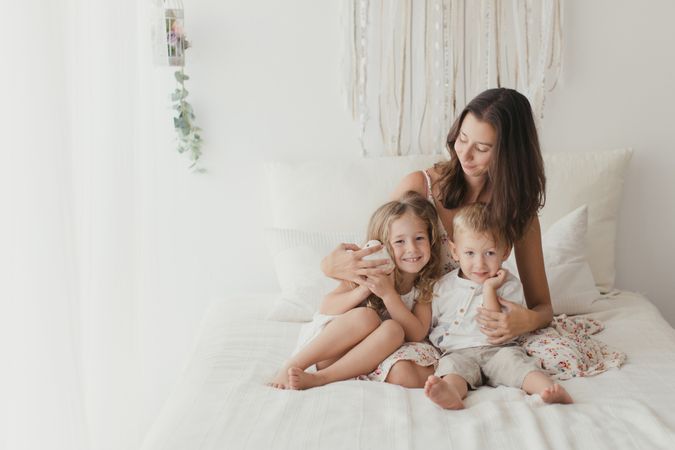 Content young mother with little kids at bedroom