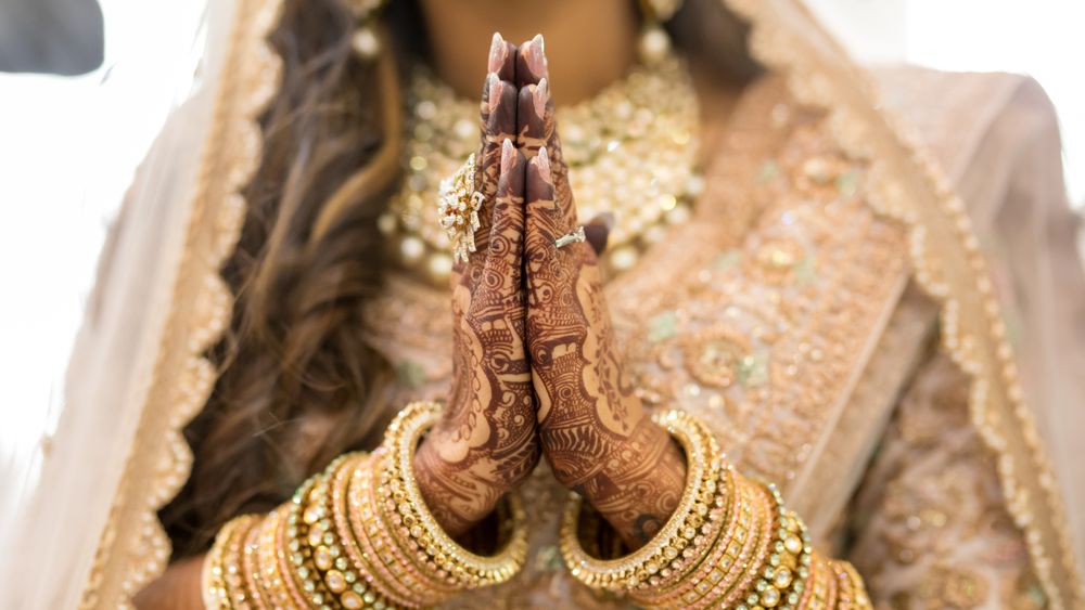 Woman in golden cultural outfit and jewelry with Mehndi tattoo