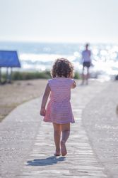 Little girl walking towards mother on seashore