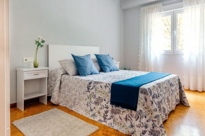 Double bedroom decorated with quilt and curtains