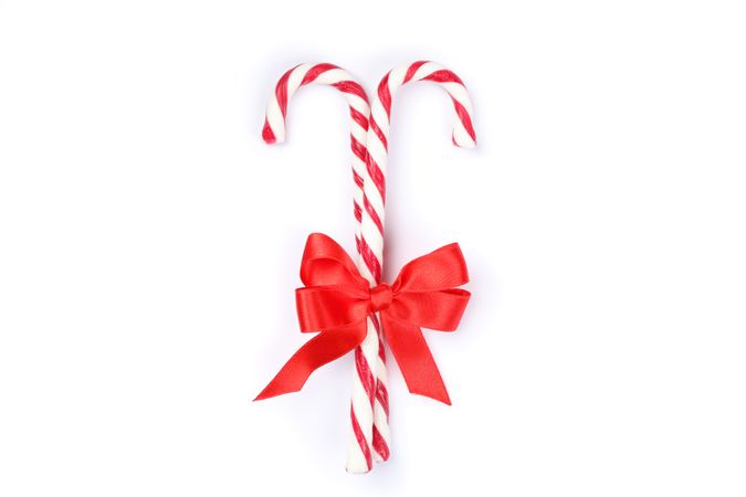 Sweet candy canes with bow isolated on blank background