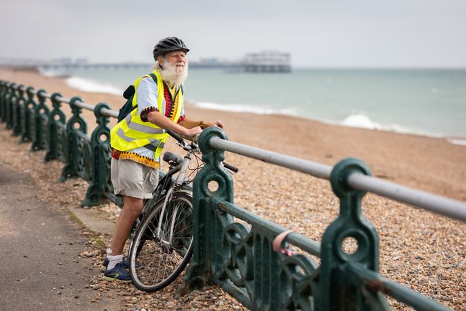 Older man with bike enjoying the coast
