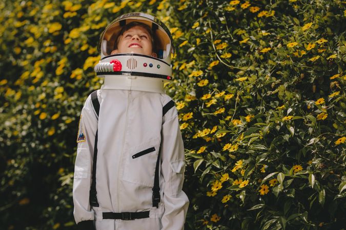 Cute boy in astronaut dress playing outdoors